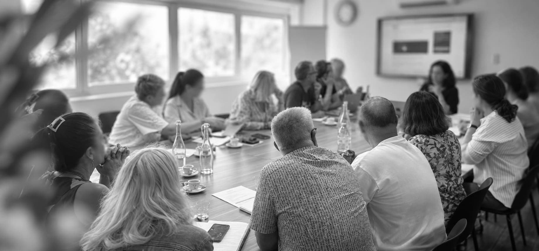 Journée de rentrée des évaluateurs INAES : une vingtaine de personnes réunies autour d’une grande table suivent une présentation projetée sur un écran.